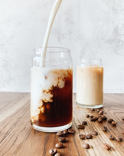 Brown and white liquid transparent glass jar
